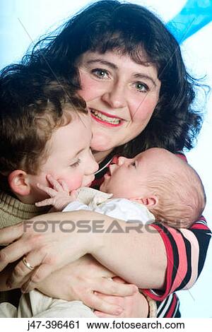 Mother cuddling her 3 year son and 8 week old baby, smiling into camera View Large Photo Image Stock Image - Mother cuddling her 3 year son and 8 week old baby, smiling into camera. Fotosearch