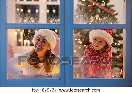 Mother & daughter looking out of the window waiting for Santa to arrive View Large Photo Image Stock Photo - Mother & daughter looking out of the window waiting for Santa to arrive. Fotosearch