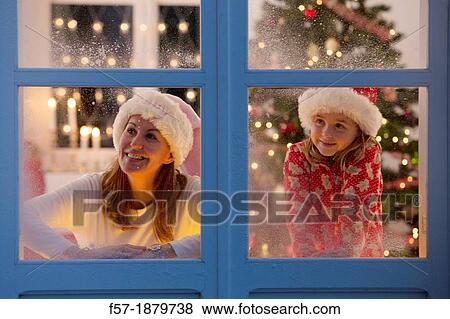 Mother & daughter looking out of the window waiting for Santa to arrive View Large Photo Image Stock Photo - Mother & daughter looking out of the window waiting for Santa to arrive. Fotosearch