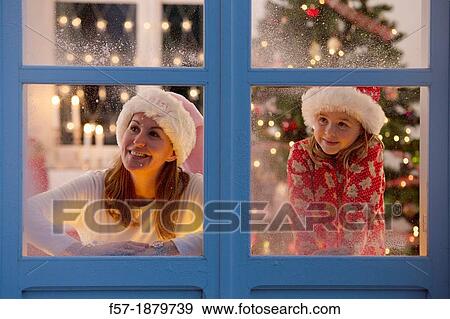 Mother & daughter looking out of the window waiting for Santa to arrive View Large Photo Image Stock Photo - Mother & daughter looking out of the window waiting for Santa to arrive. Fotosearch