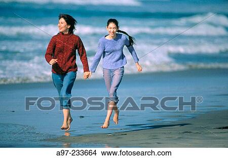Mother & daughter running on the beach View Large Photo Image Picture - Mother & daughter running on the beach. Fotosearch