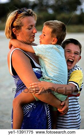 Mother embracing her sons at sunset View Large Photo Image Stock Photography - Mother embracing her sons at sunset. Fotosearch