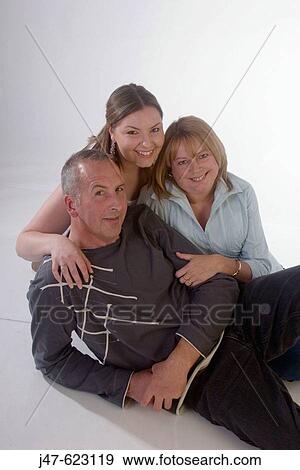 Mother, father and daughter, sitting together smiling into camera View Large Photo Image Stock Photo - Mother, father and daughter, sitting together smiling into camera. Fotosearch