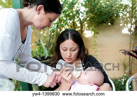 Mother feeds the baby Grandmother assists View Large Photo Image Stock Image - Mother feeds the baby Grandmother assists. Fotosearch