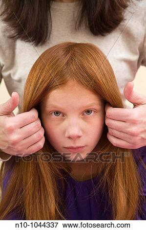 Mother fixing the hair of her preteen redhead daughter View Large Photo Image Stock Photo - Mother fixing the hair of her preteen redhead daughter. Fotosearch