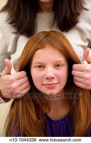 Mother fixing the hair of her preteen redhead daughter View Large Photo Image Stock Photo - Mother fixing the hair of her preteen redhead daughter. Fotosearch
