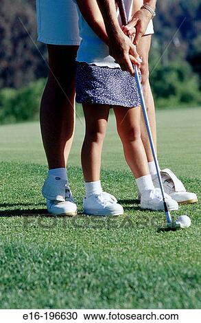 Stock Image - Mother helping daughter golf. Fotosearch