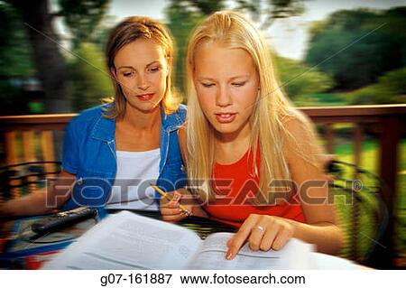 mother helping daughter student with homework studies seated at outdoor table on redwood deck View Large Photo Image Stock Photo - mother helping daughter student with homework studies seated at outdoor table on redwood deck. Fotosearch