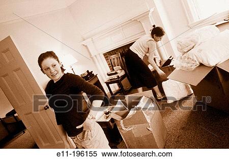 Stock Photography - Mother helps unpack daughter's things in a dorm room. Fotosearch