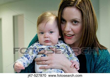 Mother holding her 6 week old baby, smiling into camera View Large Photo Image Stock Image - Mother holding her 6 week old baby, smiling into camera. Fotosearch