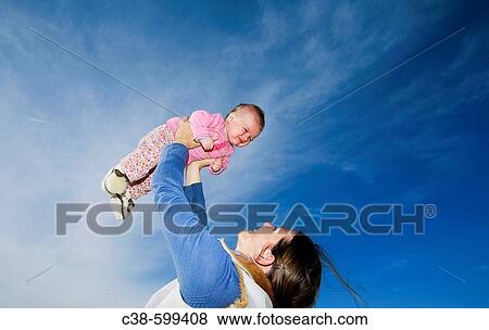 Mother Holding Her Baby Up in the Sky View Large Photo Image Stock Photo - Mother Holding Her Baby Up in the Sky. Fotosearch