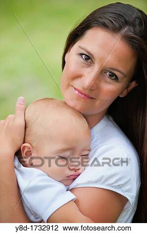 Mother in her 30s holding her baby boy of nine months View Large Photo Image Stock Image - Mother in her 30s holding her baby boy of nine months. Fotosearch