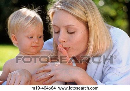 Picture - mother kisses her baby's foot. Fotosearch