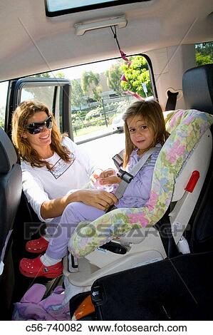 Mother locks seat belt for young child View Large Photo Image Stock Image - Mother locks seat belt for young child. Fotosearch