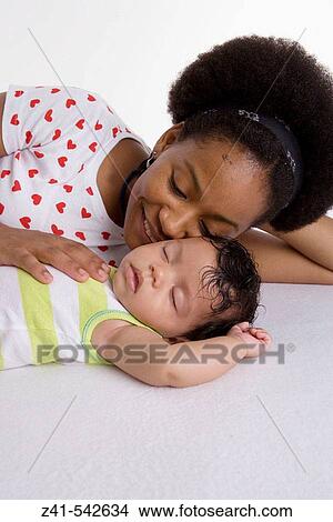 Mother looking at her sleeping baby. View Large Photo Image Picture - Mother looking at her sleeping baby.. Fotosearch