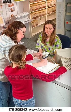 Mother, making appointment for her daughter, with receptionist, at medical office View Large Photo Image Stock Image - Mother, making appointment for her daughter, with receptionist, at medical office. Fotosearch