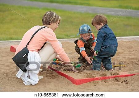 Mother playing with children in sandbox View Large Photo Image Stock Image - Mother playing with children in sandbox. Fotosearch