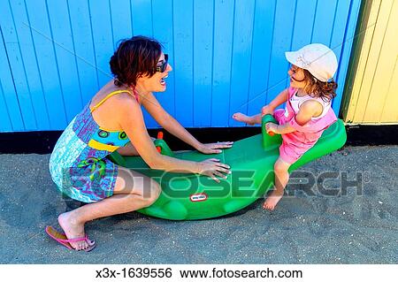 Mother playing with daughter on the beach View Large Photo Image Stock Photograph - Mother playing with daughter on the beach. Fotosearch