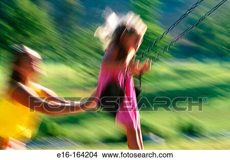 Picture - Mother pushing daughter on the swing. Fotosearch
