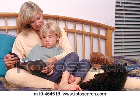 Stock Photo - mother reads to her son in bed. Fotosearch