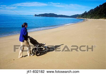 Mother strolling along deserted beach with child in pushchair New Zealand View Large Photo Image Stock Image - Mother strolling along deserted beach with child in pushchair New Zealand. Fotosearch
