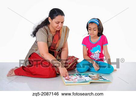 Stock Photograph - Mother teaching her daughter, Pune, India.. Fotosearch