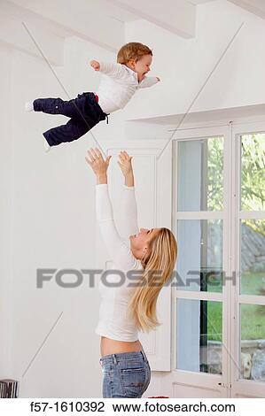 Mother throwing her one year old boy in the air View Large Photo Image Stock Image - Mother throwing her one year old boy in the air. Fotosearch