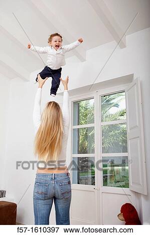 Mother throwing her one year old boy in the air View Large Photo Image Stock Photo - Mother throwing her one year old boy in the air. Fotosearch