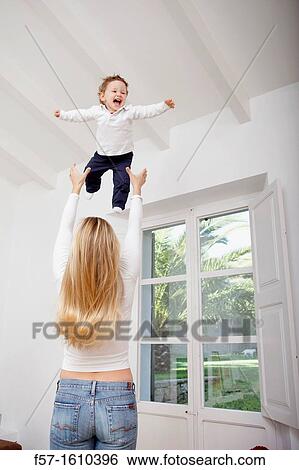Mother throwing her one year old boy in the air View Large Photo Image Stock Photograph - Mother throwing her one year old boy in the air. Fotosearch