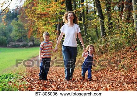 Mother with daughter and son running hand in hand on path full of leaves in fall, having fun and laughing, autumn foliage covering path in forest, autumn, fall, Zuerich, Switzerland View Large Photo Image Stock Photograph - Mother with daughter and son running hand in hand on path full of leaves in fall, having fun and laughing, autumn foliage covering path in forest, autumn, fall, Zuerich, Switzerland. Fotosearch