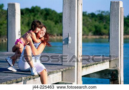 Mother with daughter sitting on a dock at the beach. Florida. USA View Large Photo Image Stock Image - Mother with daughter sitting on a dock at the beach. Florida. USA. Fotosearch