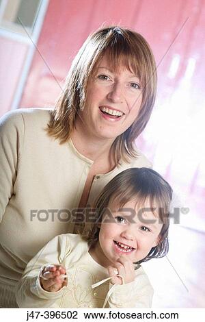 Mother with her 3 year old daughter on her knee, both smiling into camera View Large Photo Image Stock Image - Mother with her 3 year old daughter on her knee, both smiling into camera. Fotosearch
