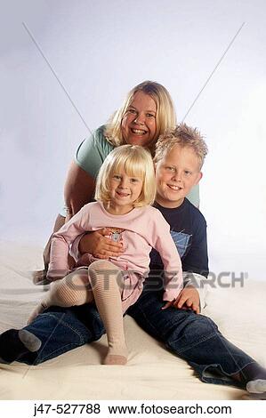 Mother with her son aged 5 and daughter aged 3 smiling into camera, studio View Large Photo Image Stock Photo - Mother with her son aged 5 and daughter aged 3 smiling into camera, studio. Fotosearch