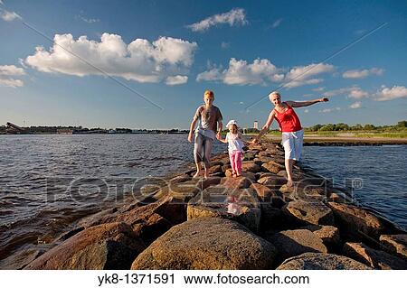 Mother with Kid Girl and Teenage Boy Holding Hands Walking on P? rnu Pier by Sea, Estonia View Large Photo Image Stock Image - Mother with Kid Girl and Teenage Boy Holding Hands Walking on P? rnu Pier by Sea, Estonia. Fotosearch