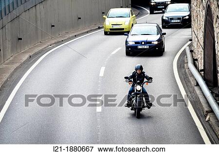 Motorcycle and cars driving around town. Ronda del Litoral, Barcelona, Catalonia, Spain. View Large Photo Image Stock Photo - Motorcycle and cars driving around town. Ronda del Litoral, Barcelona, Catalonia, Spain.. Fotosearch