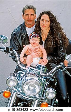 Stock Image - motorcycle couple with their baby. Fotosearch