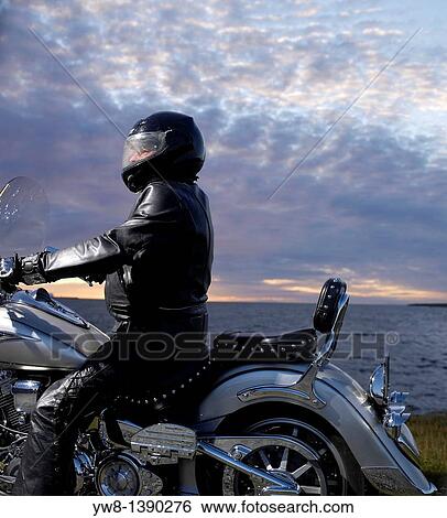 Stock Photograph - Motorcyle rider by the sea, Reykjavik, Iceland. Fotosearch