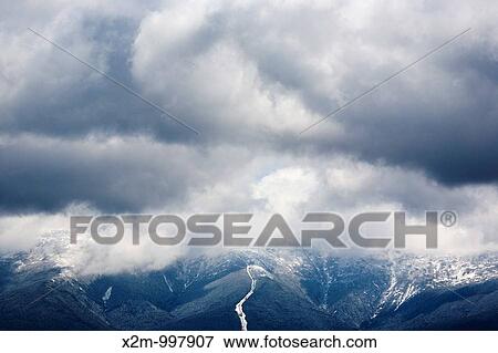 Stock Photo - Mount Washington engulfed in storm clouds from the summit of Middle Sugarloaf Mountain during the spring months Located in Bethlehem, New Hampshire USA. Fotosearch