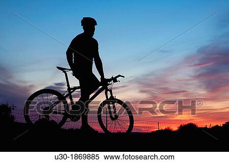 Mountain bike rider resting at dusk View Large Photo Image Stock Photography - Mountain bike rider resting at dusk. Fotosearch