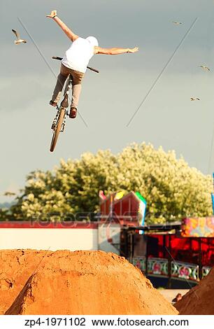 Mountain Biker Ashley Stares doing a tuck no hander over a jump with birds in the background. View Large Photo Image Stock Image - Mountain Biker Ashley Stares doing a tuck no hander over a jump with birds in the background.. Fotosearch