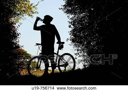 Picture - Mountain biker drinking. Fotosearch