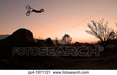 Mountain Biker, Sam Reynolds doing a superman seatgrab over a jump while the sn sets. View Large Photo Image Stock Image - Mountain Biker, Sam Reynolds doing a superman seatgrab over a jump while the sn sets.. Fotosearch