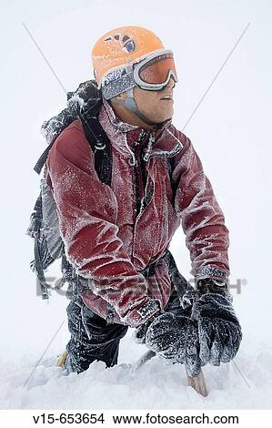 Picture - Mountaineer climbing snow covered mountain in whiteout. Fotosearch