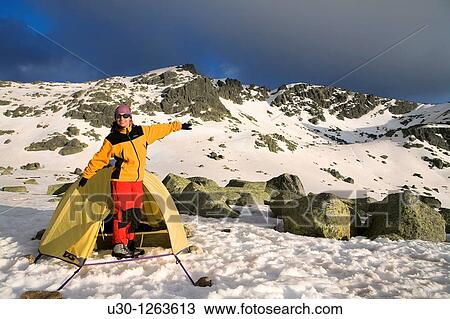 Stock Image - Mountaineer next to the yellow tent in the Sierra de B? jar Natural Park, in Salamanca province, Biosphere Reserve of Sierra de B? jar and Francia. Fotosearch