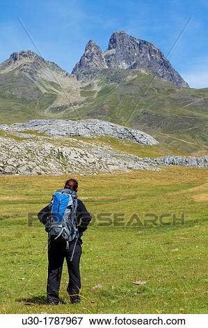 Stock Photo - Mountaineer walking near Midi D? Ossau peak, in National Park des Pyrenees, in Bearn province Atlantics Pyrenees Aquitania, France Europe. Fotosearch