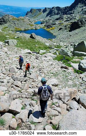 Mountaineers walking down to Trampal Lagoons, in Sierra de Gredos Regional Park? vila Castilla y Le? n Spain View Large Photo Image Picture - Mountaineers walking down to Trampal Lagoons, in Sierra de Gredos Regional Park? vila Castilla y Le? n Spain. Fotosearch