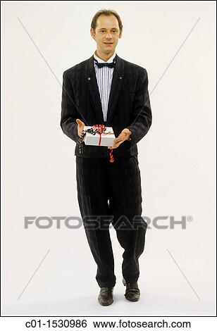 Stock Photograph - Mr Young man with black dress and present. Fotosearch