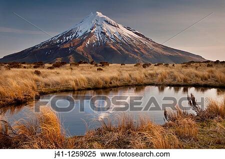Mt Egmont / Taranaki, late afternoon reflection in small tarn set among tussock slopes of Pouakai range, Taranaki. View Large Photo Image Stock Photography - Mt Egmont / Taranaki, late afternoon reflection in small tarn set among tussock slopes of Pouakai range, Taranaki.. Fotosearch