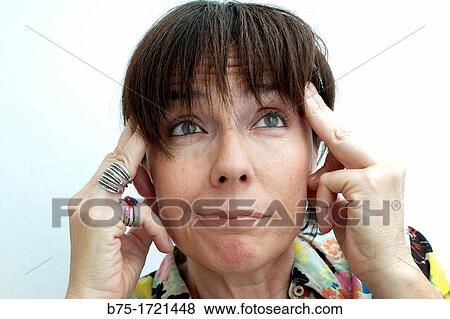 Stock Photo - mujer con las manos en las sienes preocupada, confusa y pensativa, woman with hands on temples worried, confused and thoughtful,. Fotosearch