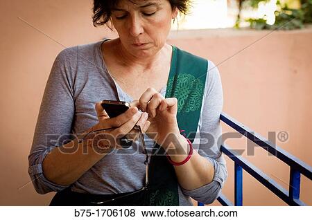 mujer en una terraza tecleando un telefono movil, woman on a terrace typing one phone View Large Photo Image Stock Photo - mujer en una terraza tecleando un telefono movil, woman on a terrace typing one phone. Fotosearch